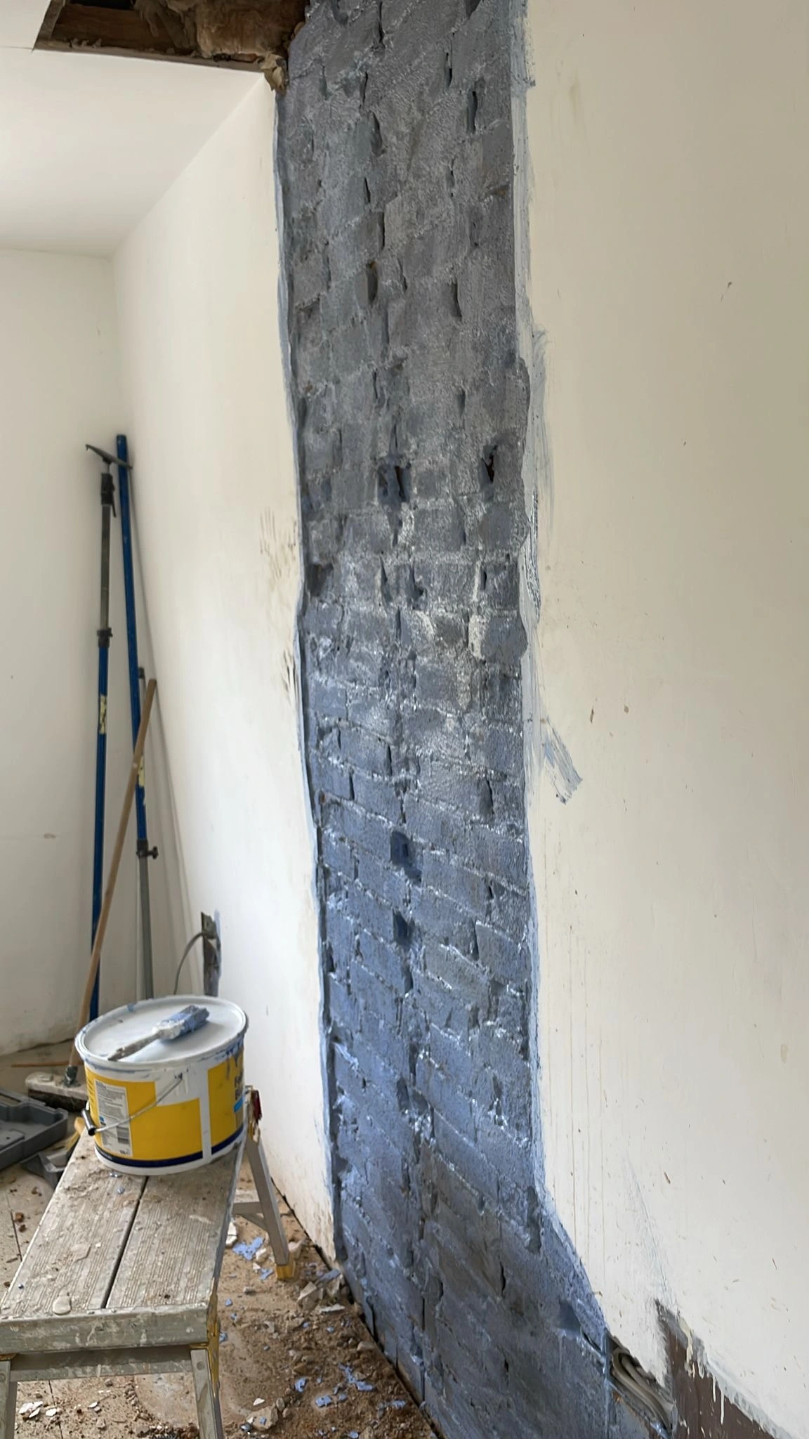 Wall section where chimney was removed coated in blue grit, ready for bonding and skim coat